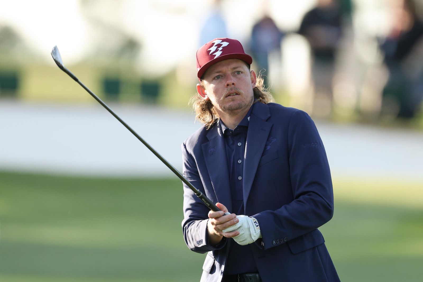 Golfer in suit playing a shot at Augusta National